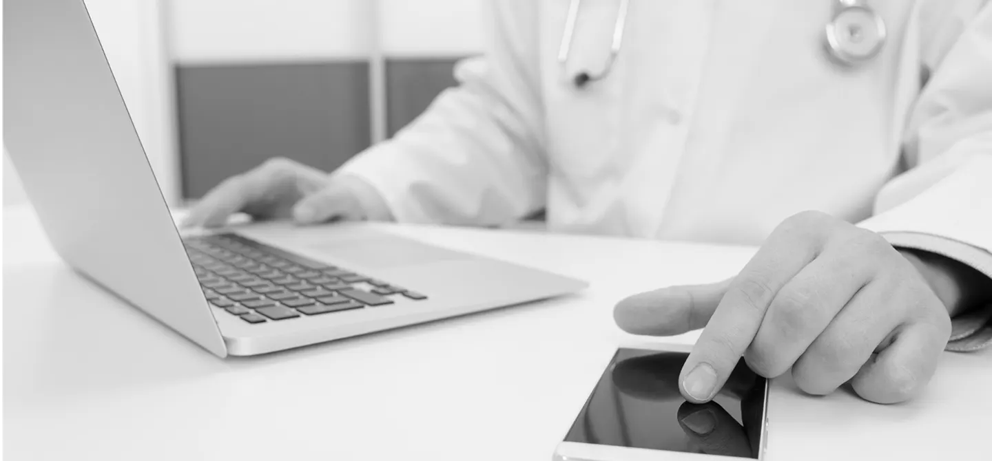 Occupational health provider documenting workplace injury details and work status at a laptop.
