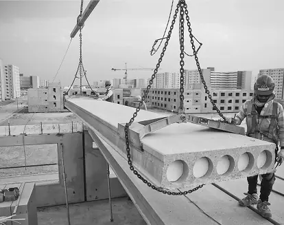 Construction crew rigging precast concrete on a jobsite where respirable crystalline silica controls apply.